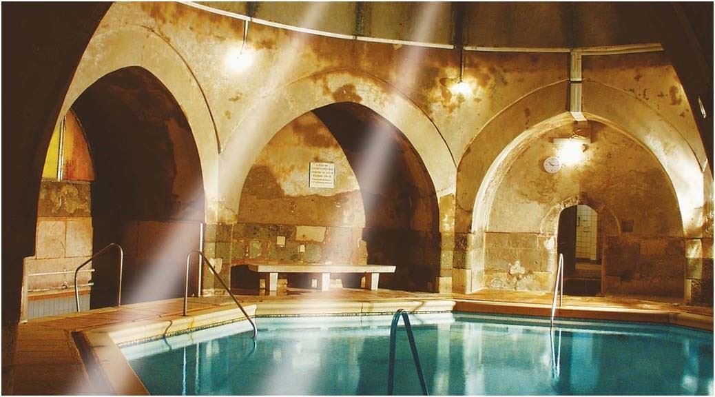 Light rays coming in empty hammam with water in the center